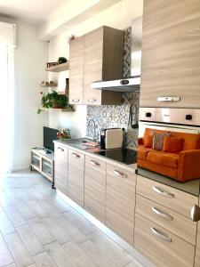 een keuken met houten kasten en een oranje bank bij Suite Locchi. Vicino Tramvia/Careggi/Meyer in Florence