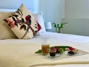 een dienblad met eten en drinken op een bed bij Suite Locchi. Vicino Tramvia/Careggi/Meyer in Florence