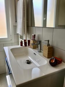 een witte wastafel in een badkamer met een spiegel bij Suite Locchi. Vicino Tramvia/Careggi/Meyer in Florence