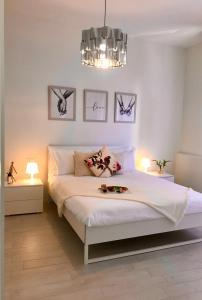 een slaapkamer met een groot wit bed en een kroonluchter bij Suite Locchi. Vicino Tramvia/Careggi/Meyer in Florence