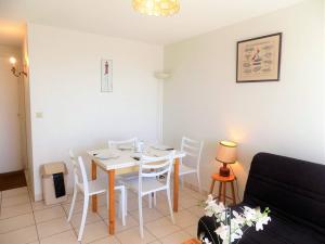 a living room with a table and chairs and a couch at Royan - APPARTEMENT VUE MER - à SEULEMENT 300m PLAGE et COMMERCES in Royan