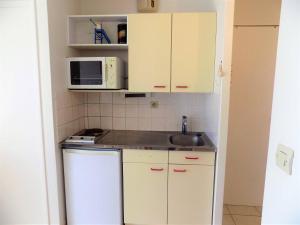 a small kitchen with a sink and a microwave at Royan - APPARTEMENT VUE MER - à SEULEMENT 300m PLAGE et COMMERCES in Royan