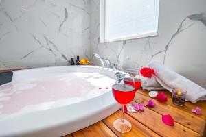 a bath tub with two glasses of wine and flowers at Yosun Apart in Kaş