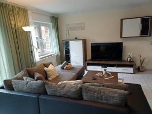 sala de estar con sofá azul y TV en Mila, en Mechernich