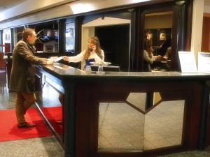 un homme et une femme debout dans un bar dans l'établissement Hotel Bavaria Brehna, à Brehna