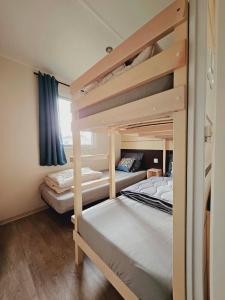 two bunk beds in a small room with at Bungalow Cosy équipé in La Boissière-de-Montaigu