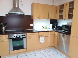 a kitchen with wooden cabinets and a stove top oven at Mila in Mechernich