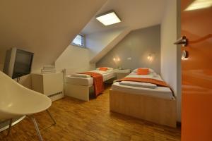 a attic room with two beds and a tv at Omnia Hotel Relax & Wellness in Janske Lazne