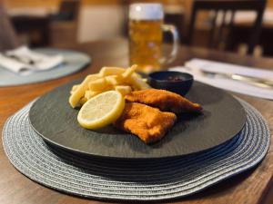 une assiette de nourriture avec du fish and chips et un citron dans l'établissement Gasthof Wäscherschloss, à Wäschenbeuren