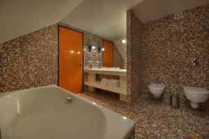 łazienka z wanną, toaletą i umywalką w obiekcie Omnia Hotel Relax & Wellness w Jańskich Łaźniach