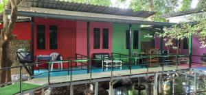 a colorful house with a deck and water at Simple Garden Resort in Koh Phangan