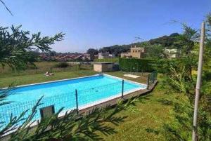 a large swimming pool in the middle of a yard at Apartamento con piscina in Llanes