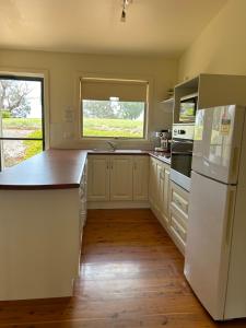 a kitchen with white appliances and a large window at Burnt Creek Cottages in Mansfield