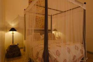 a bedroom with a canopy bed with a white comforter at Treasure Rock in Kirinda