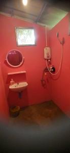 een rode badkamer met een wastafel en een raam bij Simple Garden Resort in Ko Pha Ngan