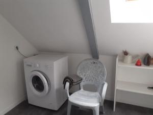 a washing machine and a chair in a room at Gite à la ferme du chateau in Saint-Dolay