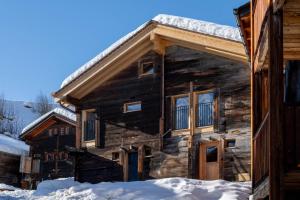 a log cabin with snow in front of it at Stall Himmel in Ritzingen