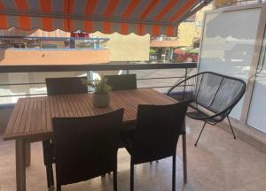 Una mesa y sillas de madera en un balcón. en Apartamento Ridaura, en Platja d'Aro
