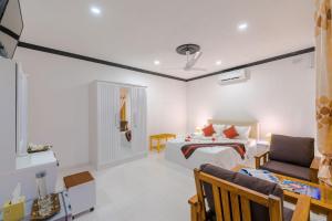a bedroom with a bed and a couch in a room at Sabba Summer Suite , Fodhdhoo in Fodhdhoo