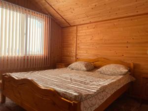 sypialnia z łóżkiem w drewnianym pokoju w obiekcie Котедж Краєвид w mieście Jabłonica