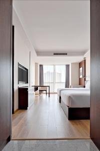 a hotel room with a bed and a television at MontClassic Hotel Chongqing in Chongqing