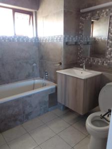 a bathroom with a tub and a sink and a toilet at 146 Stella Maris Durban Amanzimtoti in Amanzimtoti