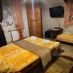 Pokój z dwoma łóżkami i telewizorem w obiekcie Zbójnicka Chata w Zieleńcu