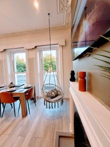een woonkamer met een schommel aan het plafond bij Cohost Partners - Elegant Escape Eastbourne in Eastbourne