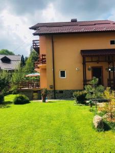a house with a yard with a green lawn at CASA de VIS in Sinaia