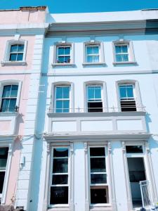 een wit gebouw met veel ramen aan een straat bij Cohost Partners - Elegant Escape Eastbourne in Eastbourne