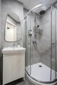a bathroom with a shower and a sink and a mirror at A13- Deluxe Apartments, Best Location, by BQA in Budapest