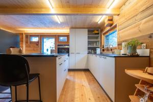 uma cozinha com armários brancos e um tecto de madeira em Stall Himmel em Ritzingen
