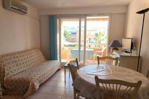 een woonkamer met een bank en een tafel bij Splendide T3 "Santa Barbara" Piscine clim parking in Cavalaire-sur-Mer
