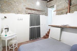 1 dormitorio con cama, lavabo y escritorio en A casa di Paola, en Castagneto Carducci