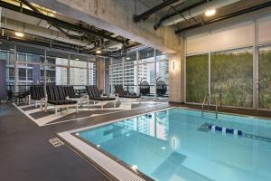 een zwembad in een gebouw met stoelen en tafels bij Streeterville jr 1br w pool gym nr Riverwalk CHI-875 in Chicago