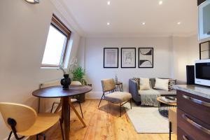 ein Wohnzimmer mit einem Tisch und einem Sofa in der Unterkunft The London Cradle - Spacious 1BDR Flat in London