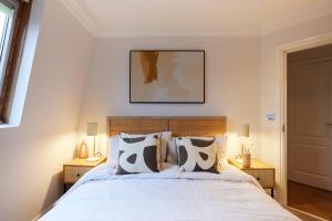 um quarto com uma cama branca com duas mesas de cabeceira em The London Cradle - Spacious 1BDR Flat em Londres