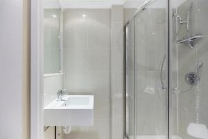 a white bathroom with a sink and a shower at The London Cradle - Spacious 1BDR Flat in London