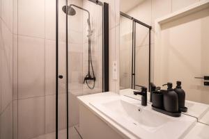 a white bathroom with a sink and a shower at A13- Deluxe Apartments, Best Location, by BQA in Budapest