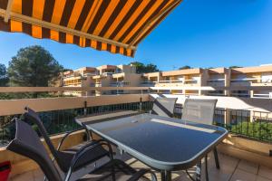 サン・ラファエルにあるAppartement Boulourisのバルコニーにテーブルと椅子が置かれたパティオ