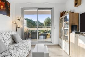 サン・ラファエルにあるAppartement Boulourisのソファとテレビのあるリビングルーム