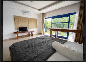 een slaapkamer met een bed en een groot raam bij Makati Walassey Villa in Karangasem