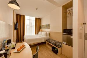 a hotel room with a bed and a table at Maxone Premier Melawai in Jakarta