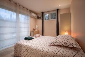 um quarto com uma cama e uma grande janela em Au son des cigales em Avignon