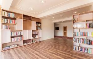 a library with white shelves filled with books at Sankar Residency in Leh
