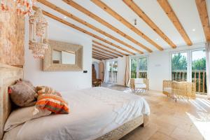 1 dormitorio con 1 cama grande en una habitación con ventanas en Villa Mediterraneo, en Sant Carles de Peralta