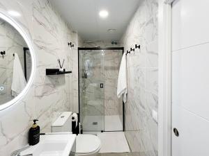 een badkamer met een douche, een toilet en een wastafel bij Studio Alborán in Málaga