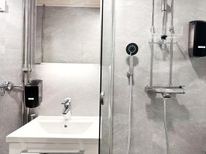 y baño con lavabo y ducha. en Aurora City Studio en Rovaniemi
