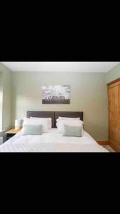 a bedroom with a bed with white sheets and pillows at Whole house in Wiltshire in Chippenham