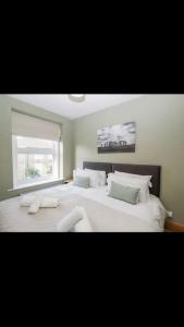 a bedroom with a large white bed with a window at Whole house in Wiltshire in Chippenham